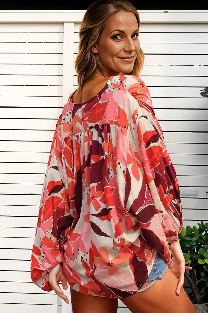 Woman wearing a bohemian floral wrap top with red and pink flowers by Boho Lane Australia