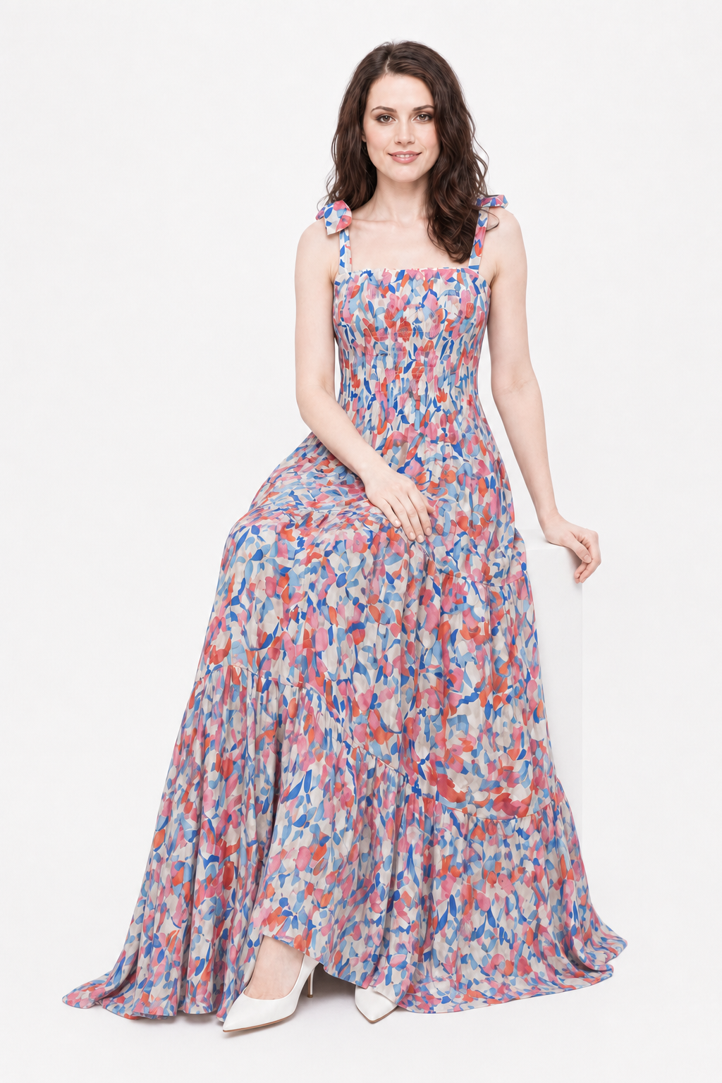 Cherry Blossom Maxi seated on Zena with elegantly crossed ankles in a white studio.