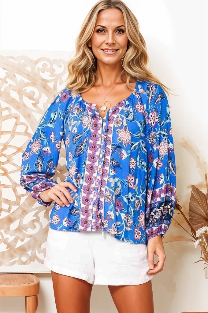 Boho Lane Australia model wearing a blue floral Hana Fleur boho blouse with long sleeves and white shorts
