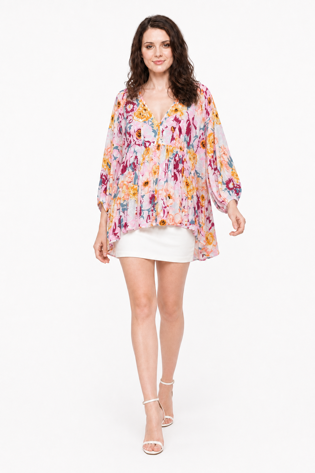Zena walking in The Layla Floral Top with a white mini skirt and white strappy heels.