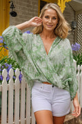 Woman wearing Flora Elegance bohemian blouse in light green paisley print with white shorts outdoors